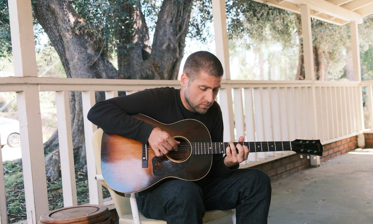 Dylan Day plays guitar during the day