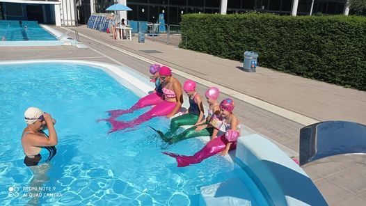Nuotare con la coda da sirena e tritone